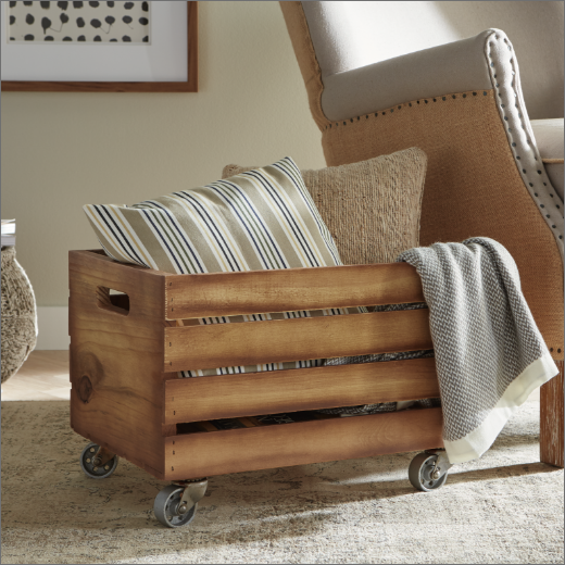 stained wheeled box with pillows and blanket inside